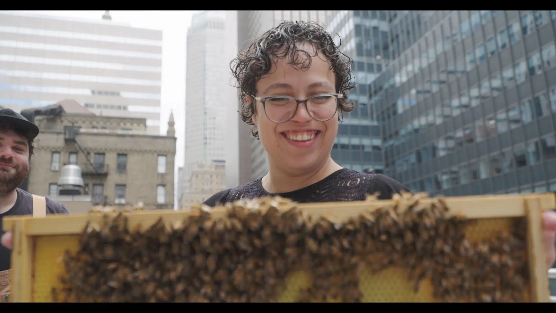 Jasmine Czarnecki, Assistant Property Manager, Cushman & Wakefield holding a frame of honey bees